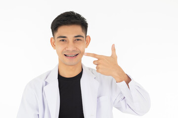 A young and handsome Asian teen man smiling to show and point finger to the good tooth with a brace. Isolated on white background