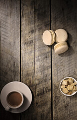 Still life with a cup of coffee and cakes on a wooden background.