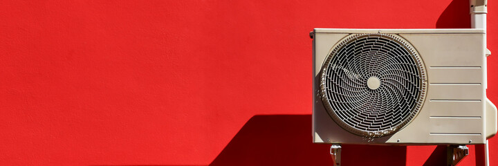 exterior Air conditioner on red wall.