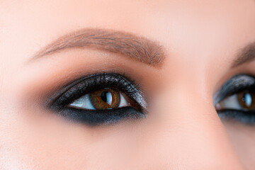 Obraz premium Closeup smoky makeup eye dark eyelids. Female eyes with beautiful bright fashion style.