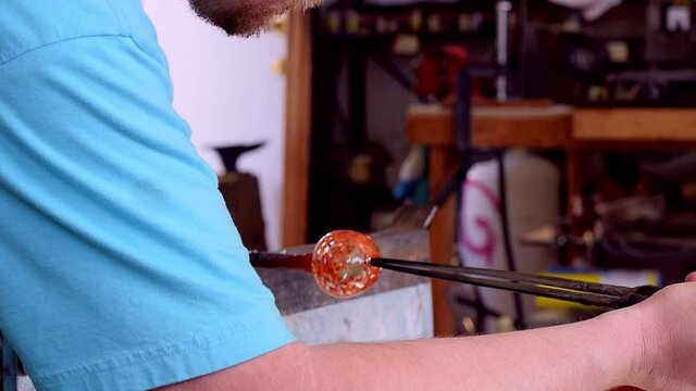 Blown glass attached to punty worked by gaffer with jacks to open up end creating mouth of a shot glass hand made artisan craftmanship.