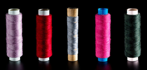 Banner with different bright silk threads for sewing, isolated on a black background. Background for a needlework and sewing banner