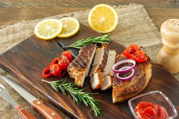 Fresh juicy roasted red meat on wooden board, with spices and vegetables. Restaurant food, delicious dish