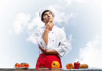 Young male chef standing with folded arms