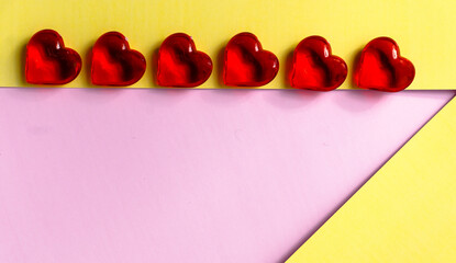 Red hearts close-up view from top, laying on a colored background for Valentine's Day. Place for text