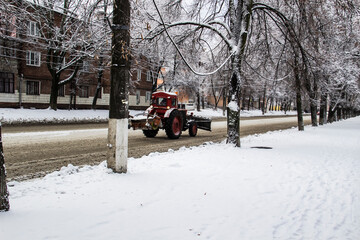 A snow plow tractor drives along a road in the city of Sumy in Ukraine.