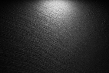 textured black slate background with spot of light