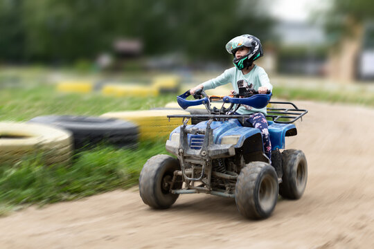a child rides an ATV on the track