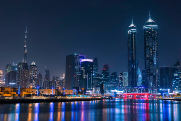 Amazing Dubai City Skyline at Night or Blue Hour. View from Dubai water canal business bay, United Arab Emirates.