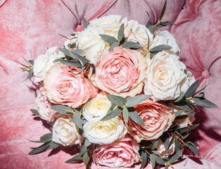 white gold wedding rings in a box and a bridal bouquet of delicate roses and greenery
