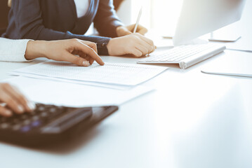 Accountant checking financial statement or counting by calculator income for tax form, hands...