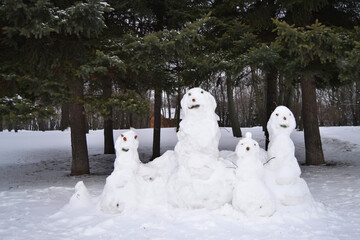 A family of snowmen in the winter forest