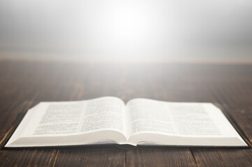 Obraz premium Open book Bible. Light from the book. On a wooden table.