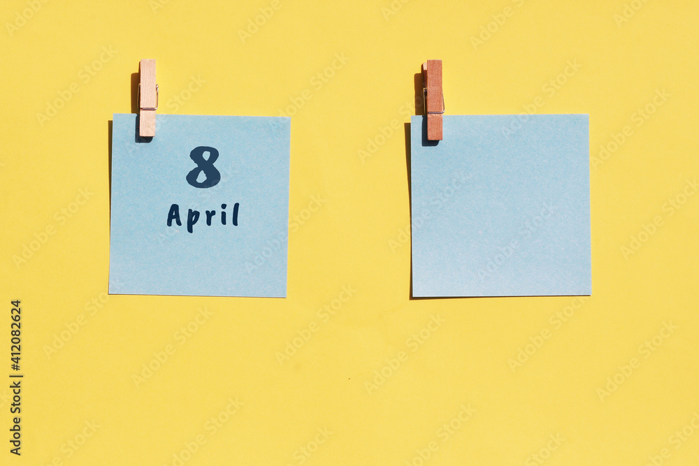 Wall mural April 8st. Day of 8 month, calendar date. Two blue sheets for writing on a yellow background. Top view, copy space. Spring month, day of the year concept