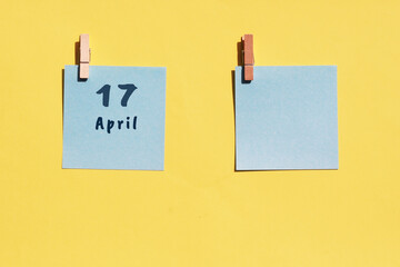 April 17st. Day of 17 month, calendar date. Two blue sheets for writing on a yellow background. Top...