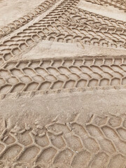 Sand with car tire marks, tracks in sand, background for template