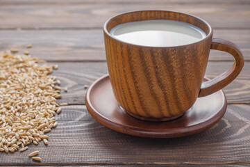 oat milk in a wooden cap at wooden background