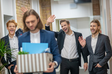 Fototapeta na wymiar Three men laughing at a leaving colleague