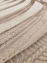 Different tire tracks in sand, no person