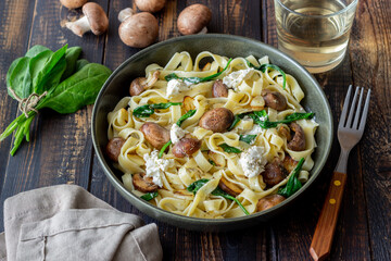 Linguine pasta with mushrooms, white cheese, spinach and garlic. Healthy eating. Vegetarian food. Diet.