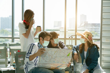Obraz premium Backpacker travelers group of Asian look at map for searching location During connecting the plane at the airport.
