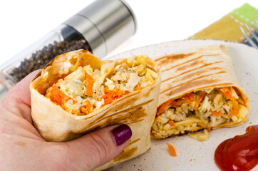 Hand holds piece of shawarma with meat.