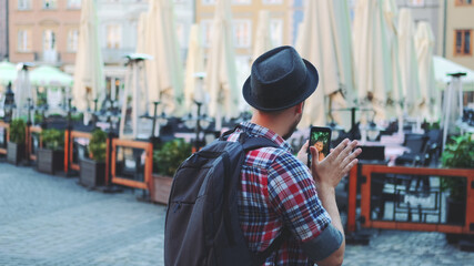 Back view of tourist making video call on smartphone with female tourist from other place. They exchanging impressions from travelings.