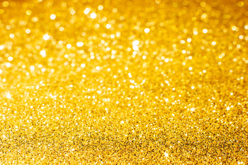 Defocused abstract colorful twinkle light background.  Gold glittery bright shimmering background use as a design backdrop.