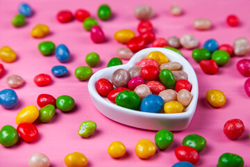 Multicolored candies in a plate in the shape of a heart