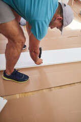 Handyman worker assembling furniture in new apartment, moving in and being hardworking.