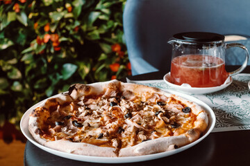 Pizza in a cafe on the table. Neapolitan cuisine.