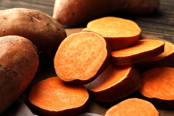 Composition of  fresh ripe sweet potatoes on wooden table background. Close-up.