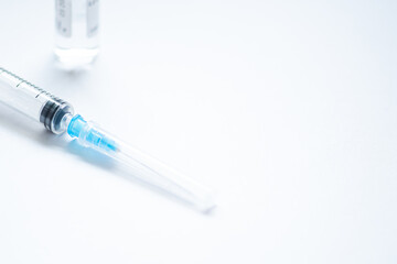 Syringe with needle and cover or top, vial or phial on a white empty space background ready to be...