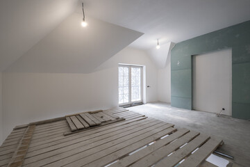 empty white room with mansard without repair and furniture with scaffolding