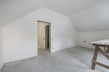 empty white room with mansard without repair and furniture with scaffolding