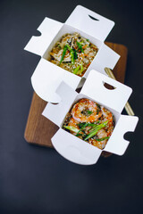 noodles with tiger prawns and sesame seeds in paper box
