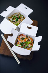noodles with tiger prawns and sesame seeds in paper box