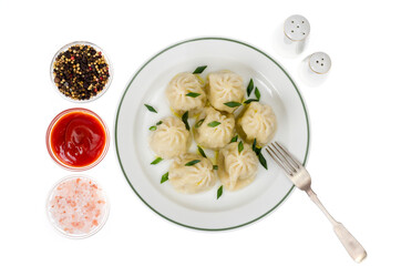 Boiled hot khinkali with meat, spices and ketchup.