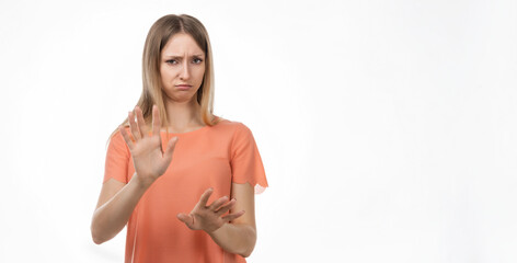 Displeased blond woman shows hands in stop or no gesture, denies problems, ignores something or...