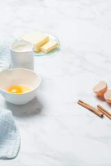 Cooking dessert concept. Fresh raw ingredients: eggs, cream and butter on white background, copy space. Background frame for baking. .