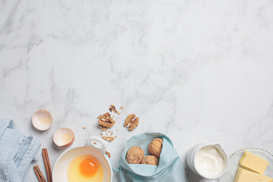 Cooking dessert concept. Fresh raw ingredients: eggs, cream and butter on white background, copy space. Background frame for baking. .