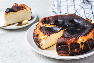 Basque burnt cheesecake on white plate. Spanish cuisine concept.
