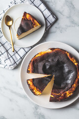 Basque burnt cheesecake on white plate, top view. Spanish cuisine concept.