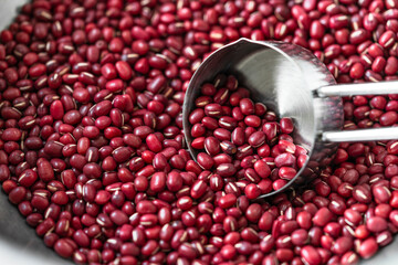 Close up red beans in measuring cup, Measuring cup scooping organic red beans in aluminum bowl.