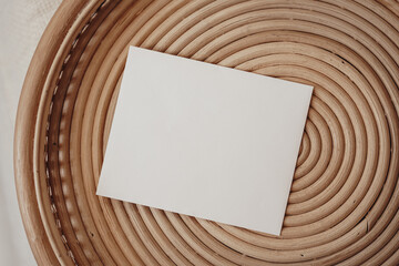 Wooden wicker tray with white paper card in boho interior