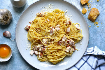 Traditional italian spaghetti alla carbonara with bacon, egg and parmesan cheese in a cream sauce. Top view with copy space.