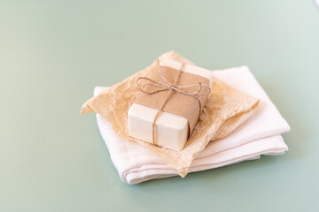 Craft paper, cotton fabric, soap, over green background. Zero waste, natural organic bathroom tools. Plastic free life. Ecological skin care, body treatment concept
