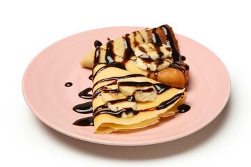 Plate of crepes with chocolate sauce and banana slices isolated on white background