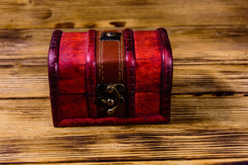 Closed vintage chest from red wood on wooden background