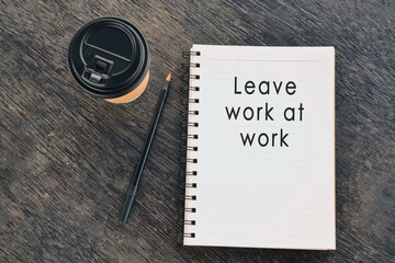 Text on notepad with disposable coffee cup and pen on wooden table